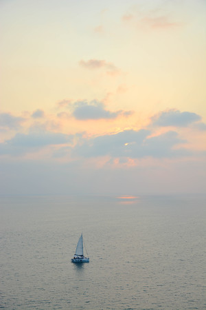 Sail boat sailing along the sea in Phuket Thailand at PromThep cape at sunset.の写真素材