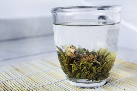 A glass bowl with hot chinese flower tea, with an orchidの写真素材