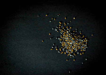 Silver and golden sprinkles on black backgroundの写真素材