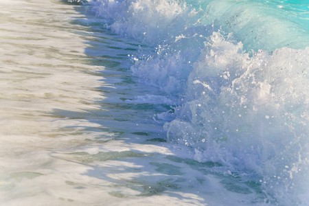 Big waves on the beach of marble from Greece, Marble beach is one of the most beautiful beaches in Thassos, the water is crystal blue and  watercolor is reflected in the waves and sea foamの写真素材