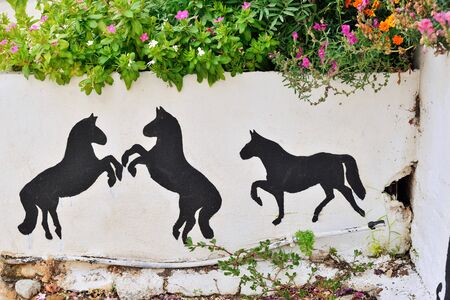 Horses painted on the wall of a fenceの写真素材