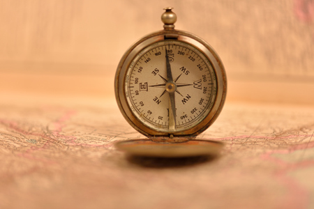 Old compass on the background of old mapsの写真素材