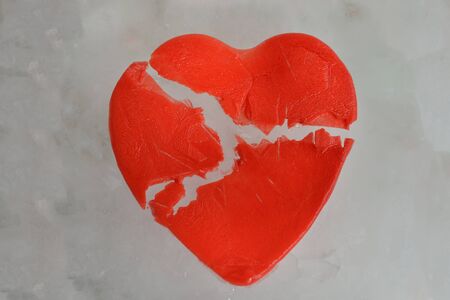 Broken red heart of ice on ice backgroundの写真素材