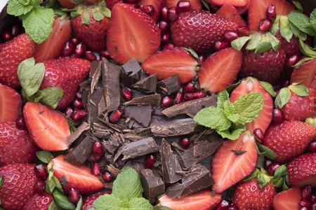 Delicious cake made in the house with chocolate, mint leaf, pomegranate and strawberry