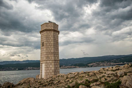 Silo lighthouse in Punta Silo (Å¡ilo), Kvarner bay on Krk island, Croatia and the view of Crikvenicaの写真素材