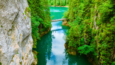 Aerial view over a beautiful turquoise colored water with cliffs on both sides. Photography was taken from a drone at Scropoasa lake located in Romania.の写真素材