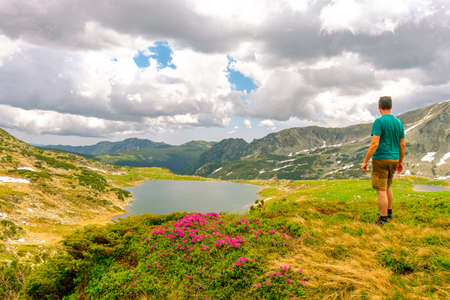 Beautiful view of a glacial lake in the mountains under cloudy sky. View of Bucura lake located in Retezat mountains in Romania. View of a mountain lake in a rainy day.の写真素材