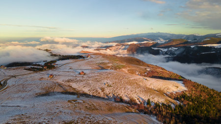Aerial photography of mountains at sunset. Landscape photography of mountains with clouds in a valley shot from a drone at sunset in the winter season.の写真素材