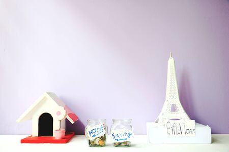 Jars of coins save money and model home on a white background.の写真素材