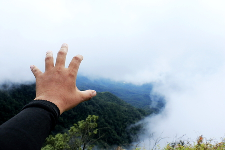 Man hand sign on Mountain background. A man travel on forest  and show hand in fright.he make sigh going to mountain.の写真素材