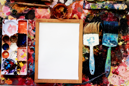 paint brushes and drawing paper on a colorful background.の写真素材