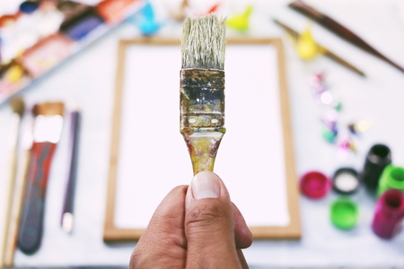 hand holding paintbrush on tool art background.の写真素材