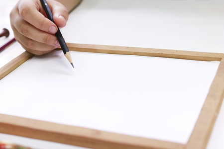 Hand little girl holding Pencil to draw on paperの写真素材