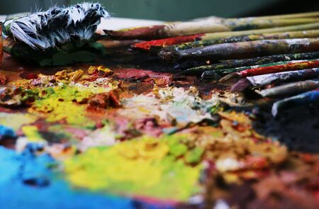 Close up paint brushes on a color full painter in black ground. の写真素材