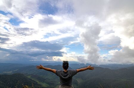 Women hand sign on sky background. Woman travel on cliff and see sun up and blue sky.They are in...