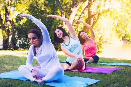 Group people doing yoga in park. They are sleeping on mat and doing yoga in morning.they are relax time and good health.Photo concept yoga and good health.の写真素材