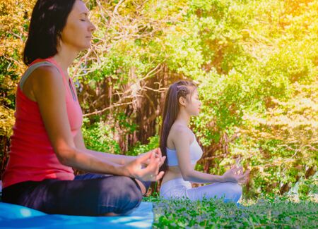 Group people have meditation for yoga.In the morning they are sitting on mat and play yoga in park.good air,hobby,Zen,Photo concept freedom and good health.の写真素材