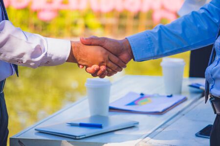 Businessman,They are shake hands  in park.They are talking business.He is holding business bag.Photo...