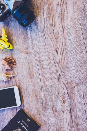 Top view accessories for travel on old wood.Cellphone,a yellow plane toy , Shells à¸¡Old camera...