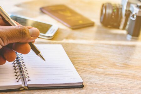 Hand holding a pen and notebook. Men are writing recorded on notebook a daily basis. Camera Phones...