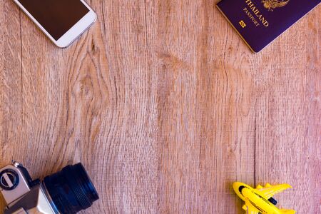 Top view accessories for travel on old wood.Cellphone,a yellow plane toy , Shells à¸¡Old camera...