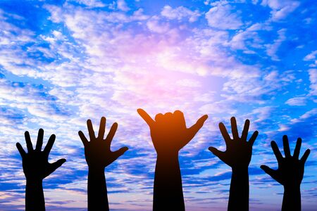 Silhouetted of hand photo.Hand show up in to sky  with sunset.Hand is symbol Comment and democratic.の写真素材