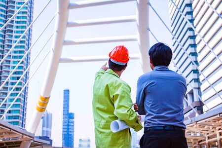 Working engineer.They are see sky and building.A man hand pointer mean spirit beside building...