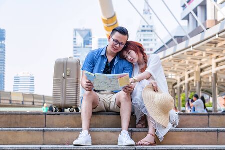 Young Asian couple are walking in city. A man carry woman. They are happy at one of landmark  in Bangkok city. Photo Asian tourism and couple concept.の写真素材