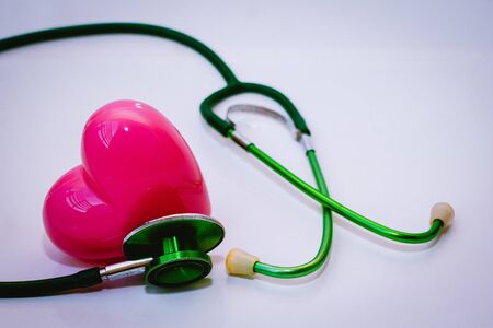  Green stethoscope and pink Heart.They are check heart wave on white background. Photo concept healthcare good feel.の写真素材