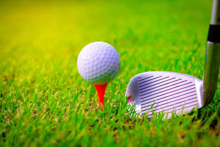 Golf ball and golf clubs on the Course. Golf ball on Orange tee. They are prepare to shot. Photo for health and game.の写真素材