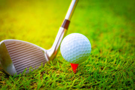 Golf ball and golf clubs on the Course. Golf ball on Orange tee. They are prepare to shot. Photo for health and game.の写真素材