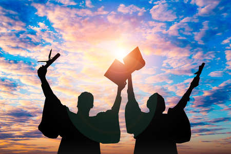 Silhouette of Student Graduation. They are seeing sunset.They are standing and show hand.They are celebration in Graduate, Education,academic,
Photo concept Silhouette and Success.の写真素材