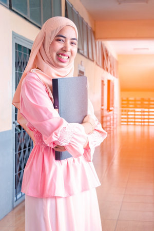 Young student Islamic woman. She is sitting and reading book.She is smile and relax time, woman Portrait, Photo concept portrait and life style.の写真素材