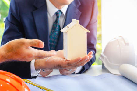 à¸ºBody part.Business man pointing hand in to modal home. He is present model home for building.They are in office, Spirit, develop ,connection. Photo concept work and Successの写真素材