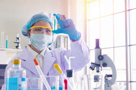 Body past scientist working in laboratory.She is looking in test tube.She is trying and research...