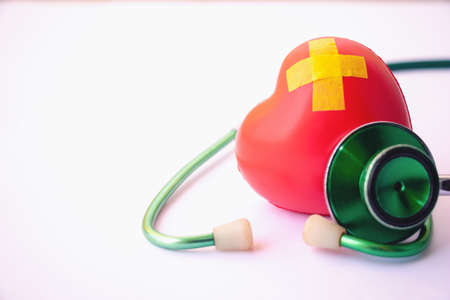 Green stethoscope and red heart.They are check heart wave on white background. Photo concept healthcare good feel.の写真素材