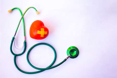 Green stethoscope and red heart.They are check heart wave on white background. Photo concept healthcare good feel.の写真素材