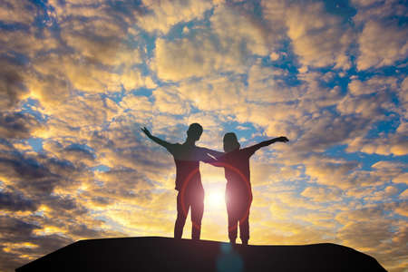 Man and woman in love. They are standing and see the sun set.Woman wearing a hat and man.Man hugging woman.sweetheart

,couple,Photo concept Silhouette and love.の写真素材