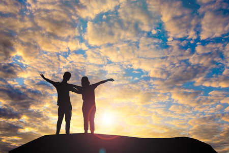 Man and woman in love. They are standing and see the sun set.Woman wearing a hat and man.Man hugging woman.sweetheart

,couple,Photo concept Silhouette and love.の写真素材