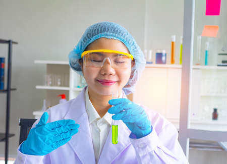Asian female scientist working in the laboratory. She is holding a test tube.の写真素材