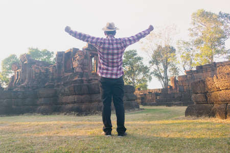Asian man sitting and reading book in old stone temple,he is reading book and relaxing time. learning day,clever,intelligent,Photo vacations and Lifestyle concept idea.の写真素材