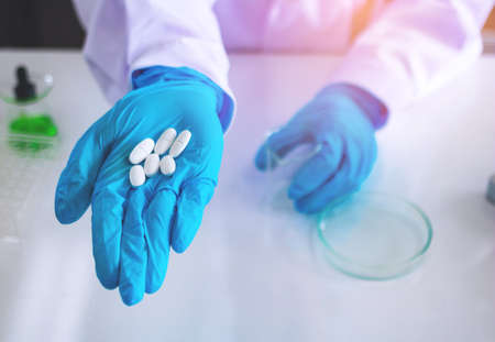 Body past scientist working in laboratory.Chemical scientist show white medicine.She...