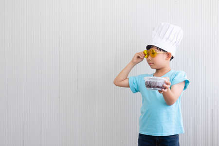 Portrait Asian cute boy.The chef child boy standing with food box in room.lovely,nice,development.photo concept knowledge and  Kid portrait.の写真素材
