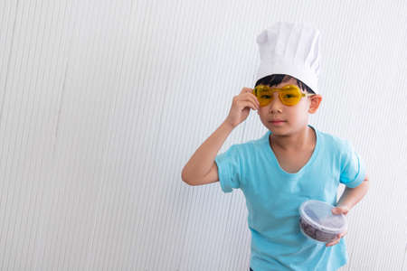 Portrait Asian cute boy.The chef child boy standing with food box in room.lovely,nice,development.photo concept knowledge and  Kid portrait.の写真素材