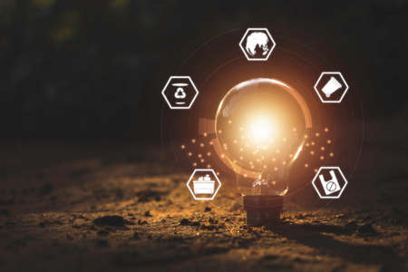Hand holding light bulbs and icons global warming.Creative thinking ideas for work on desk.searching for new ideas,Knowledge,successful, wisdom.Photo concept of knowledge and education.の写真素材