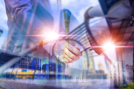 Double exposure picture. Picture mix  building city and businessman is Shake hands show Confident. Picture concept action man and business.の写真素材