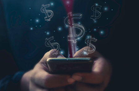 Close up of man using mobile smart phone with dollar sign on screenの写真素材