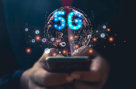 Businessman using mobile phone with 5G network hologram. Technology concept.の写真素材