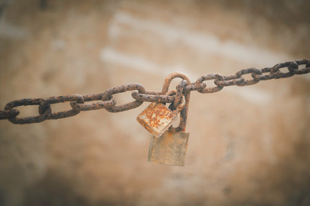 Rusty padlock and chain on old wall background, vintage toneの写真素材