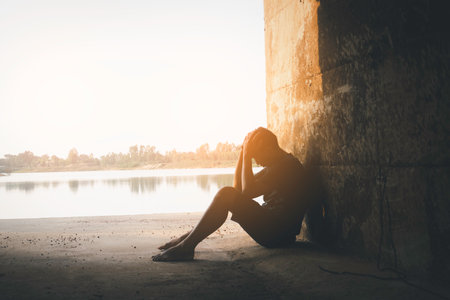 Asia you man sitting alone.He sitting in cave.man very sad and depressed.sad,alone,suicide,despair,sickness,photo health and disappointment concept.の写真素材